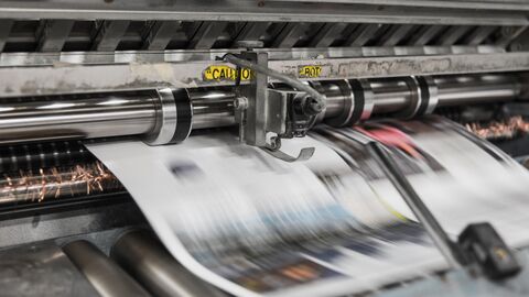 Druckerei Bedrucktes Papier wird von einer Maschine ausgegeben.