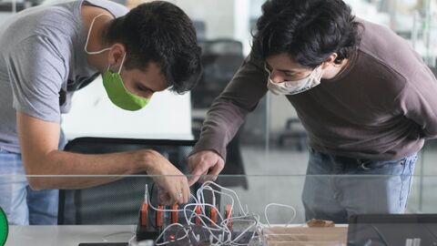 Junge Männer in der Ausbildung Zwei junge Männer mit Maske in der Ausbildung
