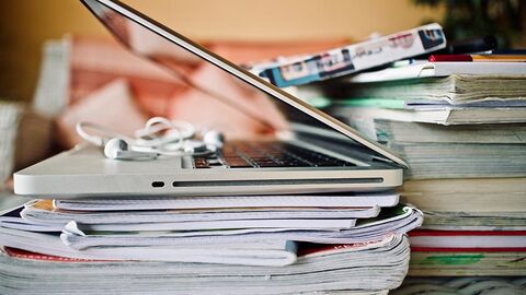 Notebook auf Heften und Büchern Auf einem Stapel von Heften und Büchern liegt ein Notebook.