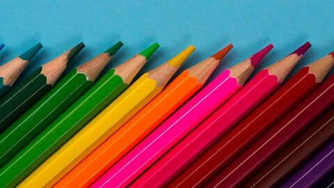 Verschiedenfarbige Buntstifte liegen geordnet nebeneinander.