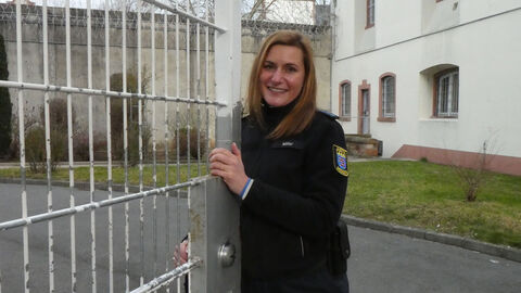 Rosa Müller steht an einem Metallzaun vor der JVA Dieburg
