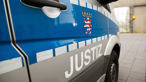 Seite eines Justizbusses mit Justizlogo.
