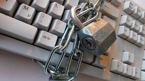 Datenschutz (Symbolbild) Kette mit Schloss ist um eine Tastatur gewickelt.